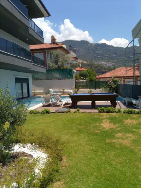 Bahce, barbeku ve cocuk oyun parkı olanağı ve buyuk bir havuzu olan geniş aileler için ideal